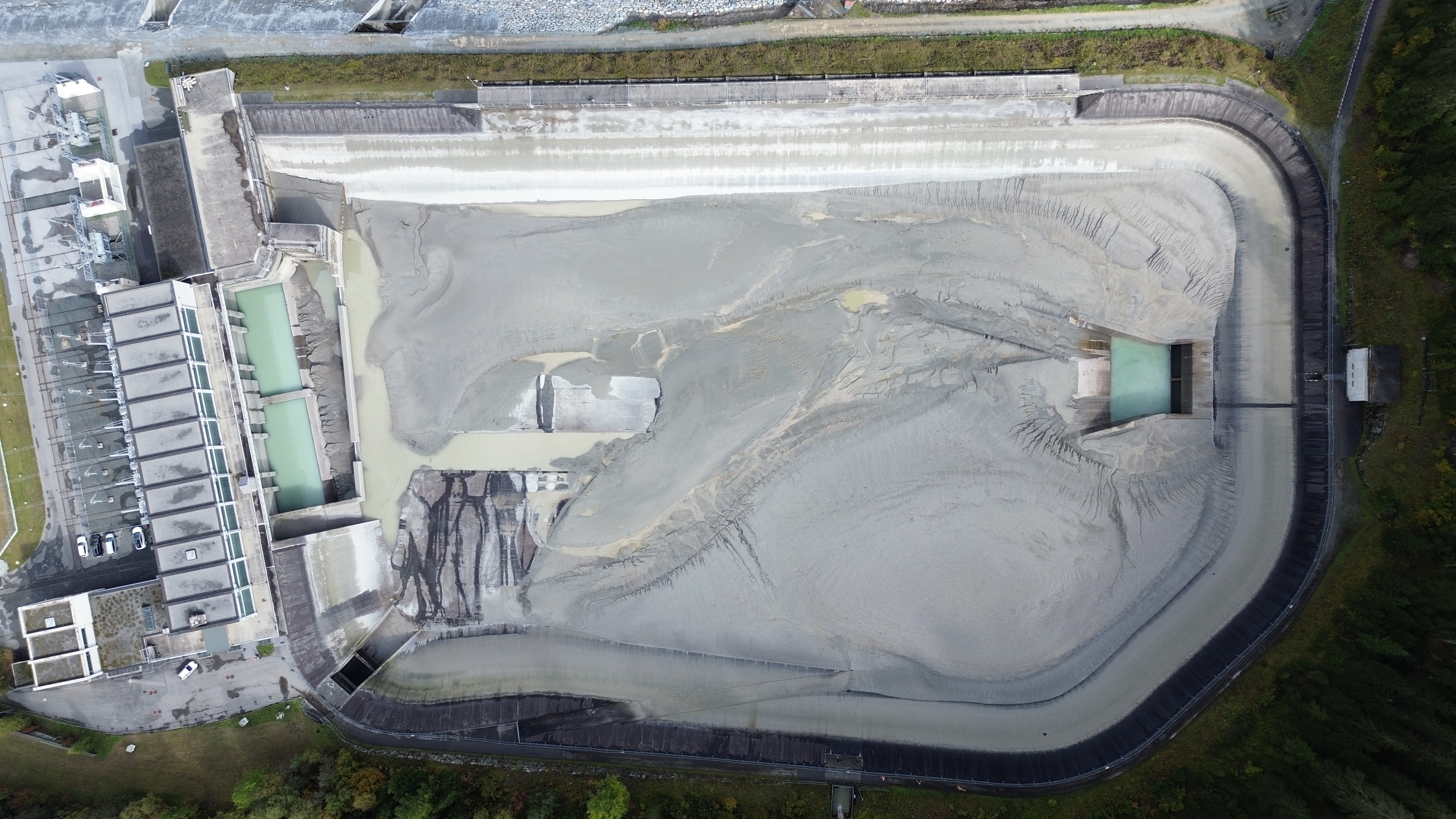 Luftaufnahme des entleerten Ausgleichsbeckens Pradella mit Sedimentablagerungen