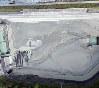 Luftaufnahme des entleerten Ausgleichsbeckens Pradella mit Sedimentablagerungen