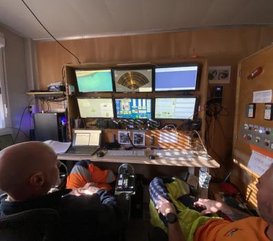 Freilegung Grundablass_Piloten, die den Bagger von einem Container auf der Staumauerkrone aus steuern